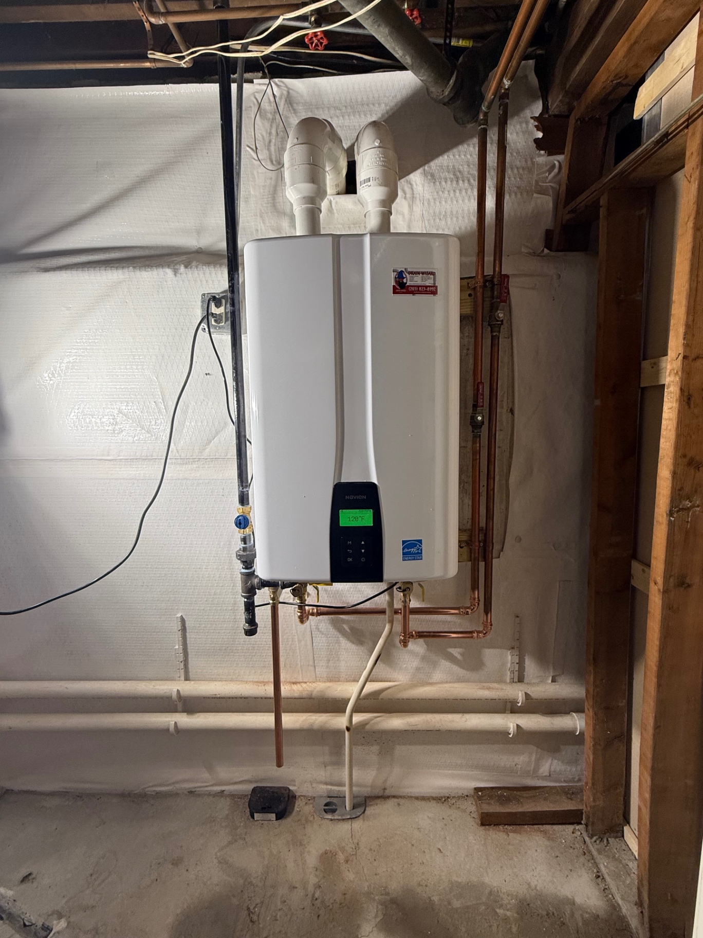 Navien high-efficiency tankless water heater installed in a Connecticut basement — clean copper manifold, PVC intake/exhaust, and endless hot water on demand.