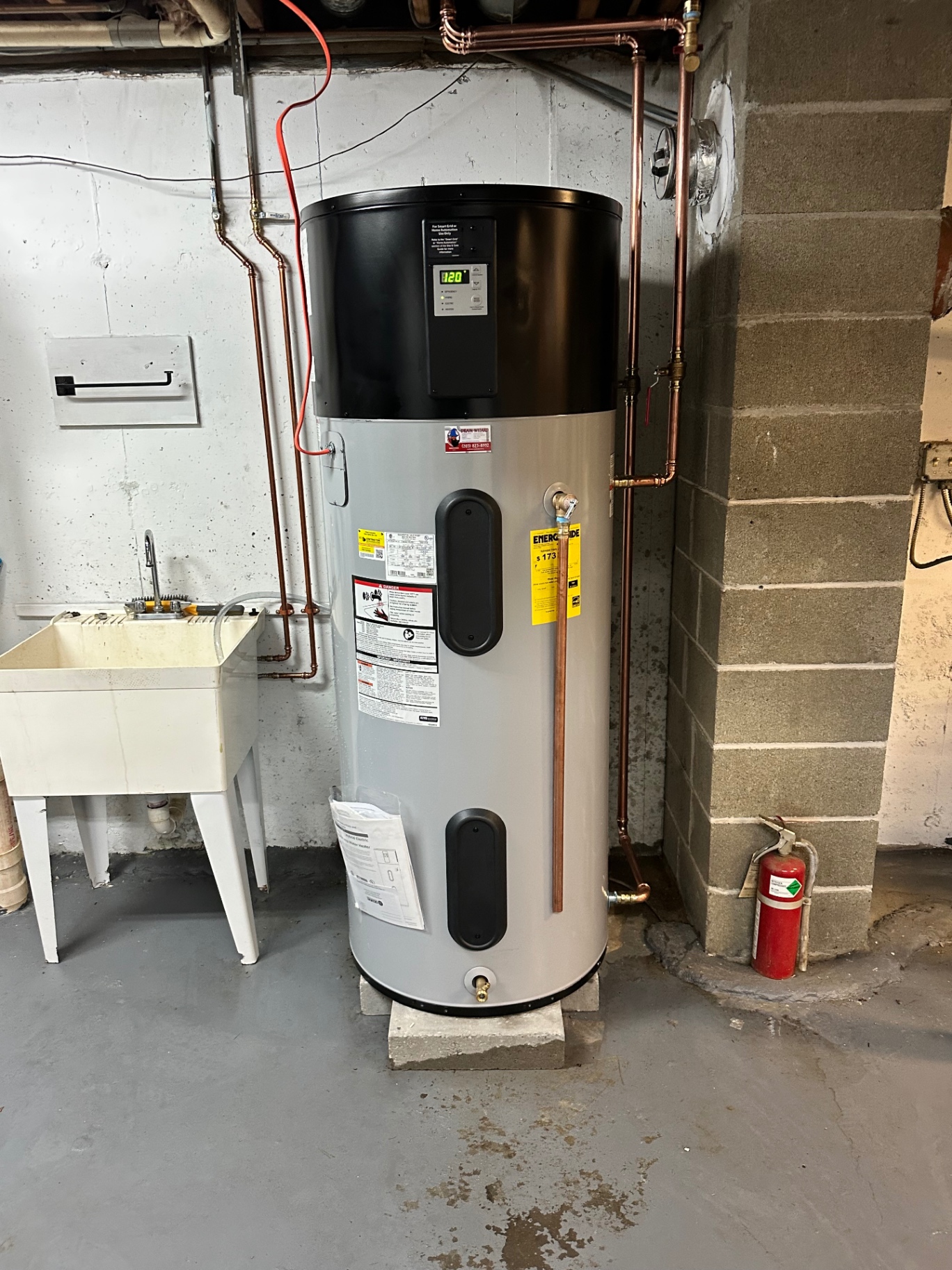 High-efficiency hybrid heat pump water heater — dramatically lower electric bills than a standard electric tank, installed on a level pad with proper condensate drainage.