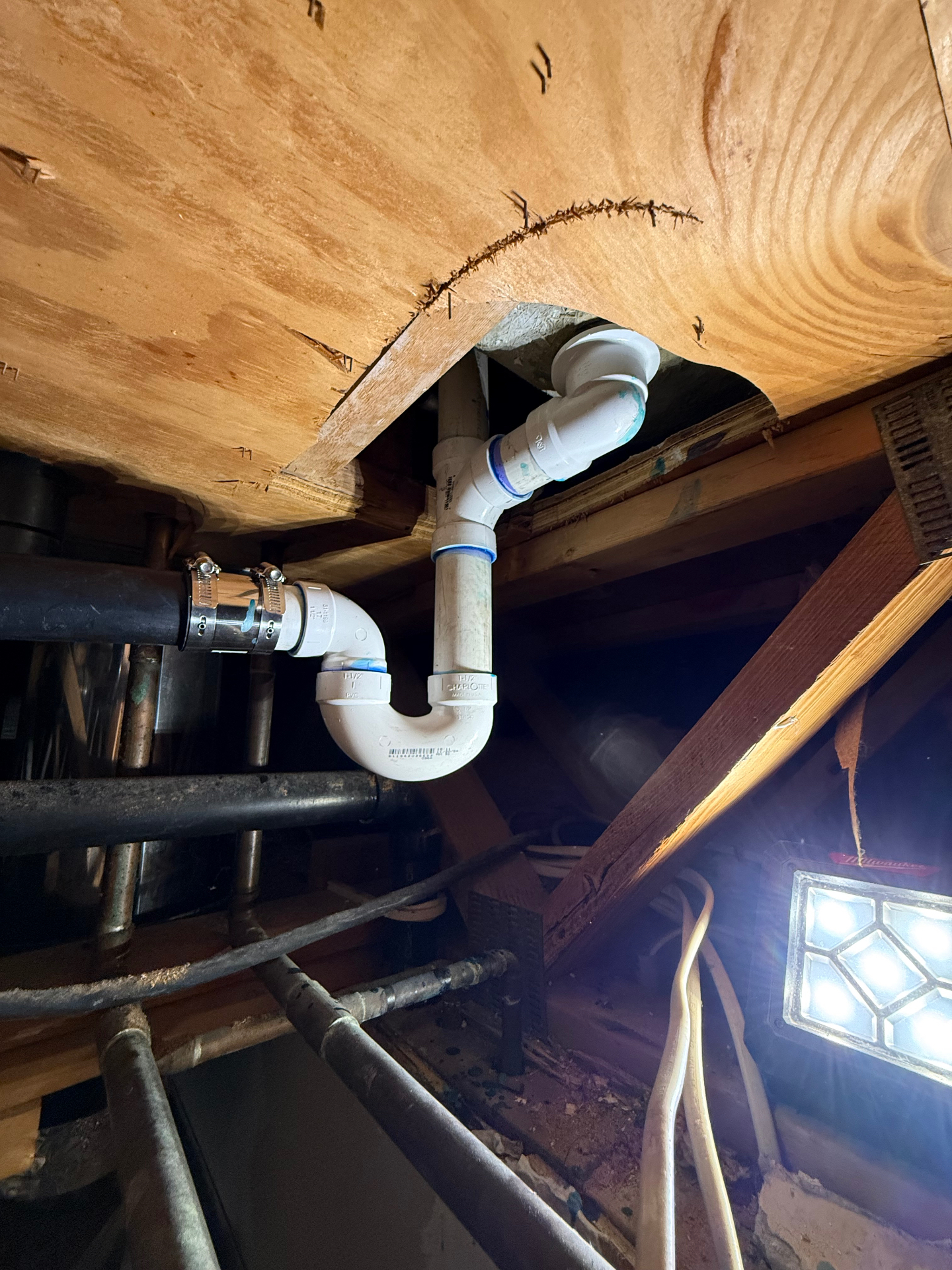 New PVC drain assembly installed beneath a Hamden floor