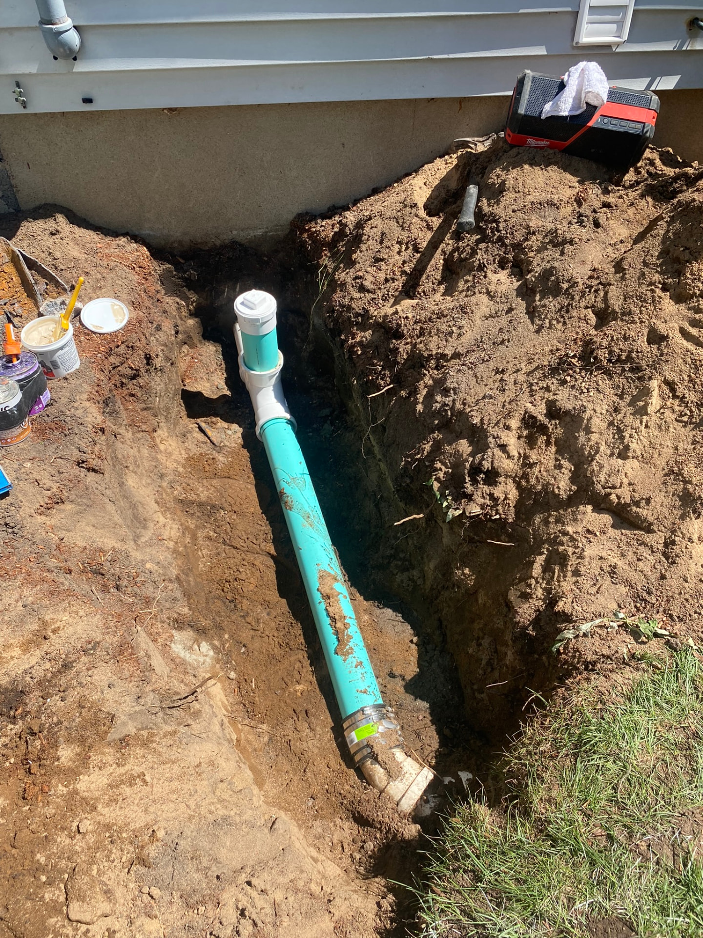 New underground drain line with cleanout riser set in an open trench beside a North Haven, CT home