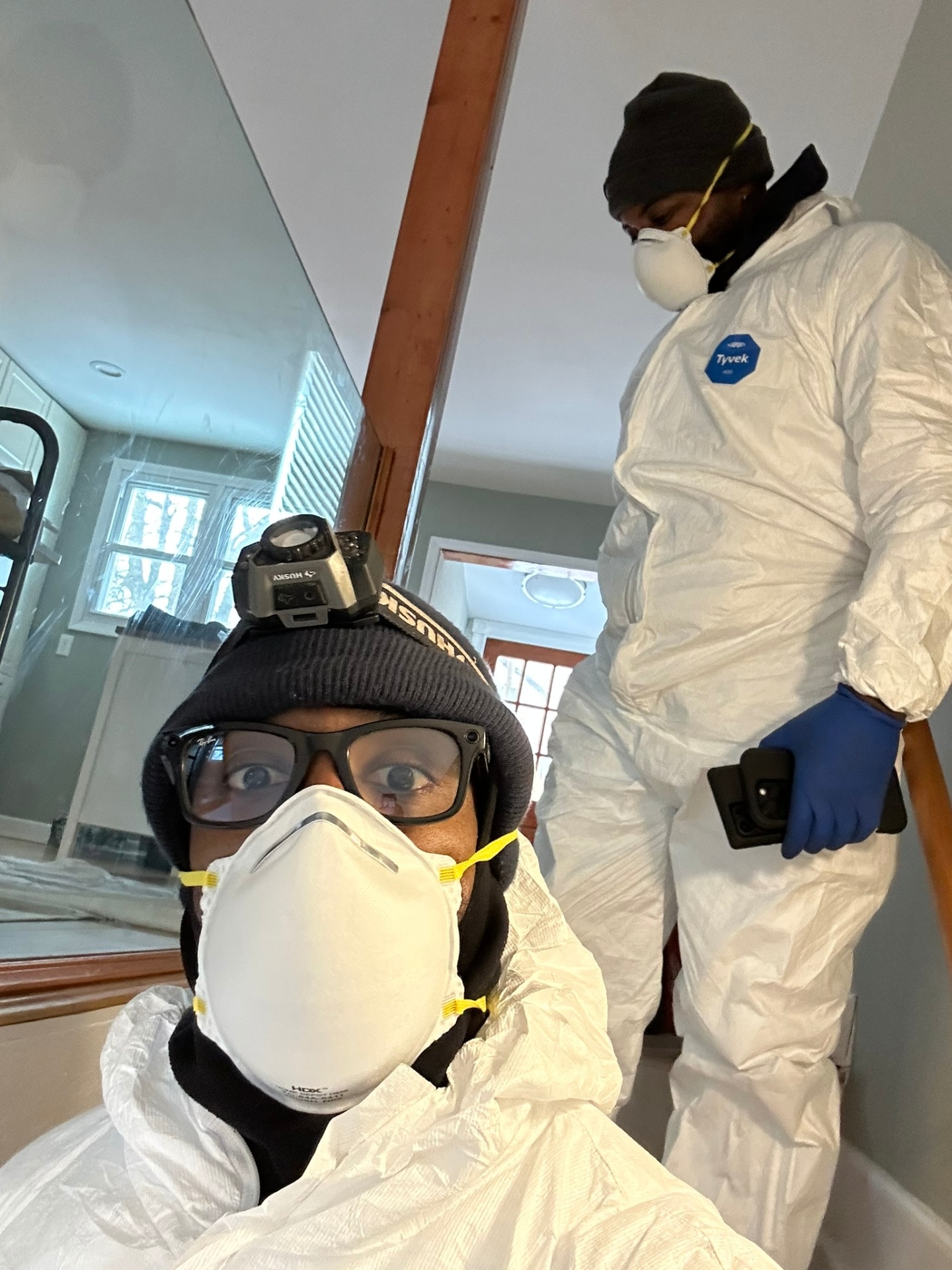 Rob and James suited up in Tyvek and respirators before entering a contaminated water loss — proper PPE is standard on every Category 2 and Category 3 job.
