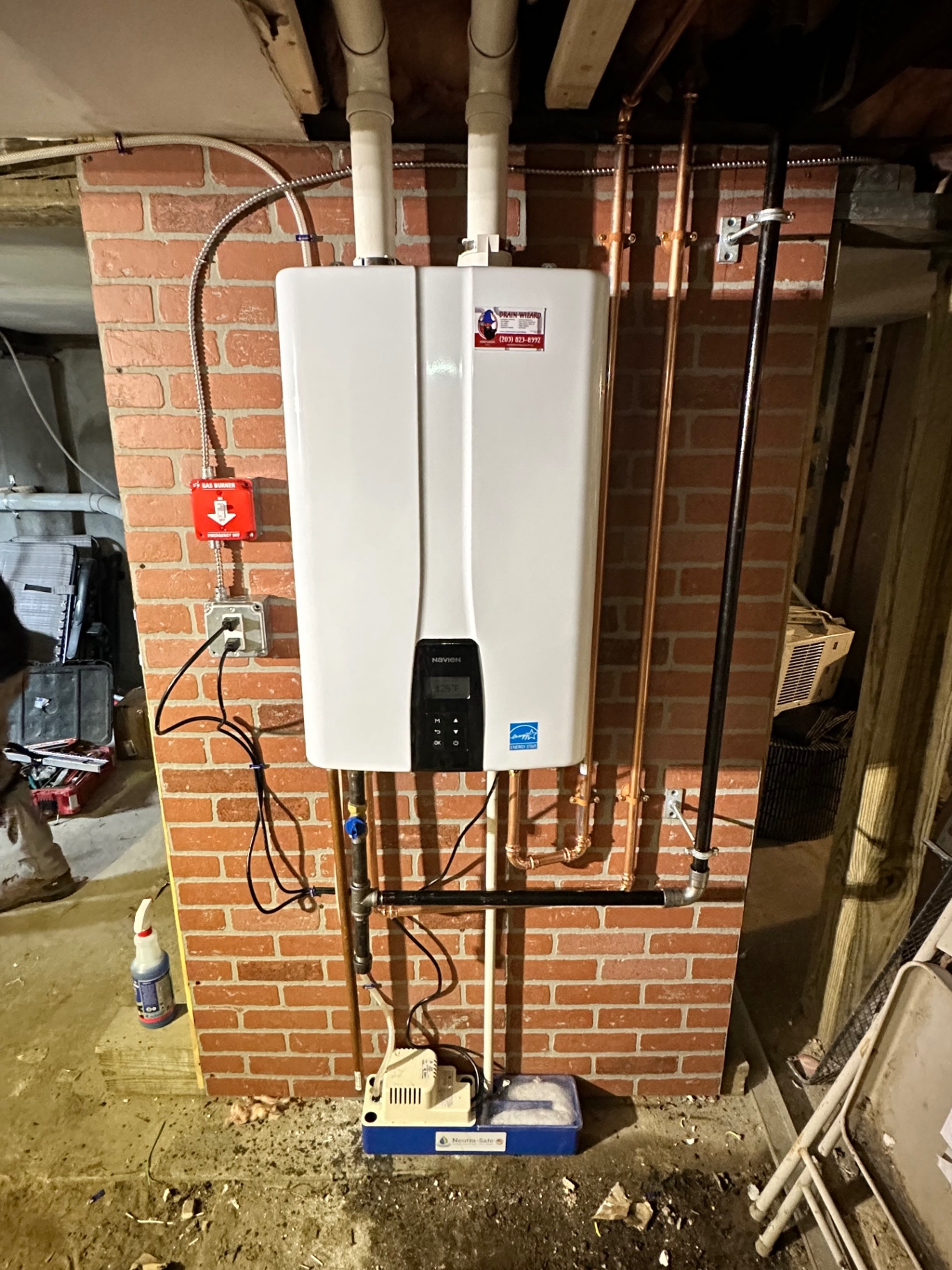 Same Navien tankless install, powered up and running at 125°F — condensate neutralizer, gas emergency shut-off, and dedicated circuit all code-compliant.