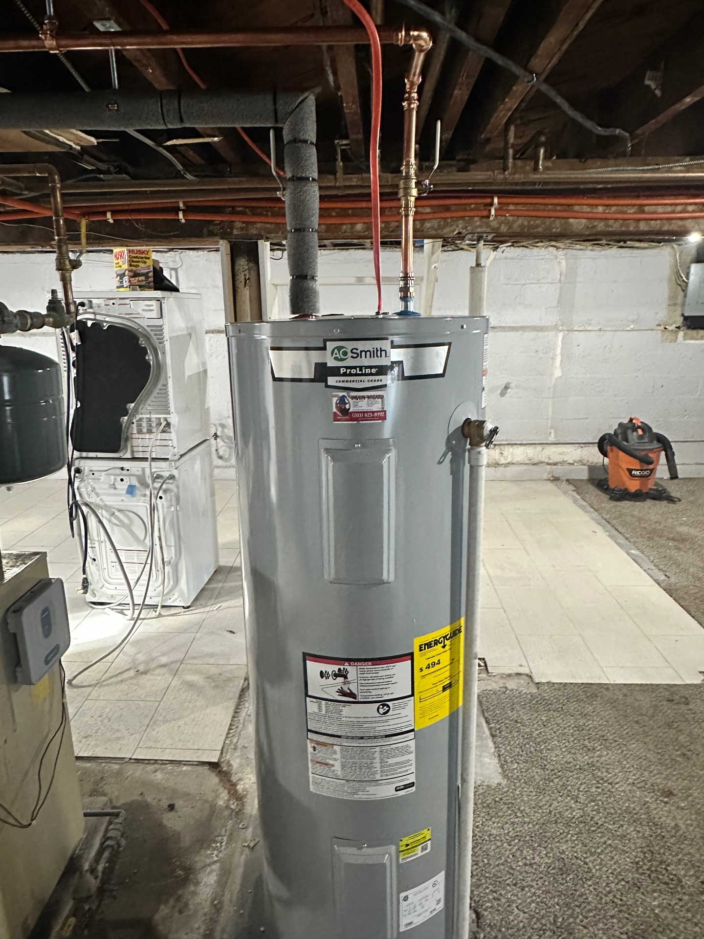 A.O. Smith ProLine commercial-grade electric tank water heater installed with new copper supply lines and expansion tank — a reliable workhorse for busy households.