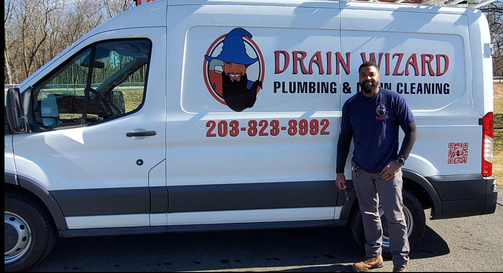 Robert Gathers, Owner and Connecticut P1 Master Plumber at Drain Wizard Plumbing, standing next to the branded service van