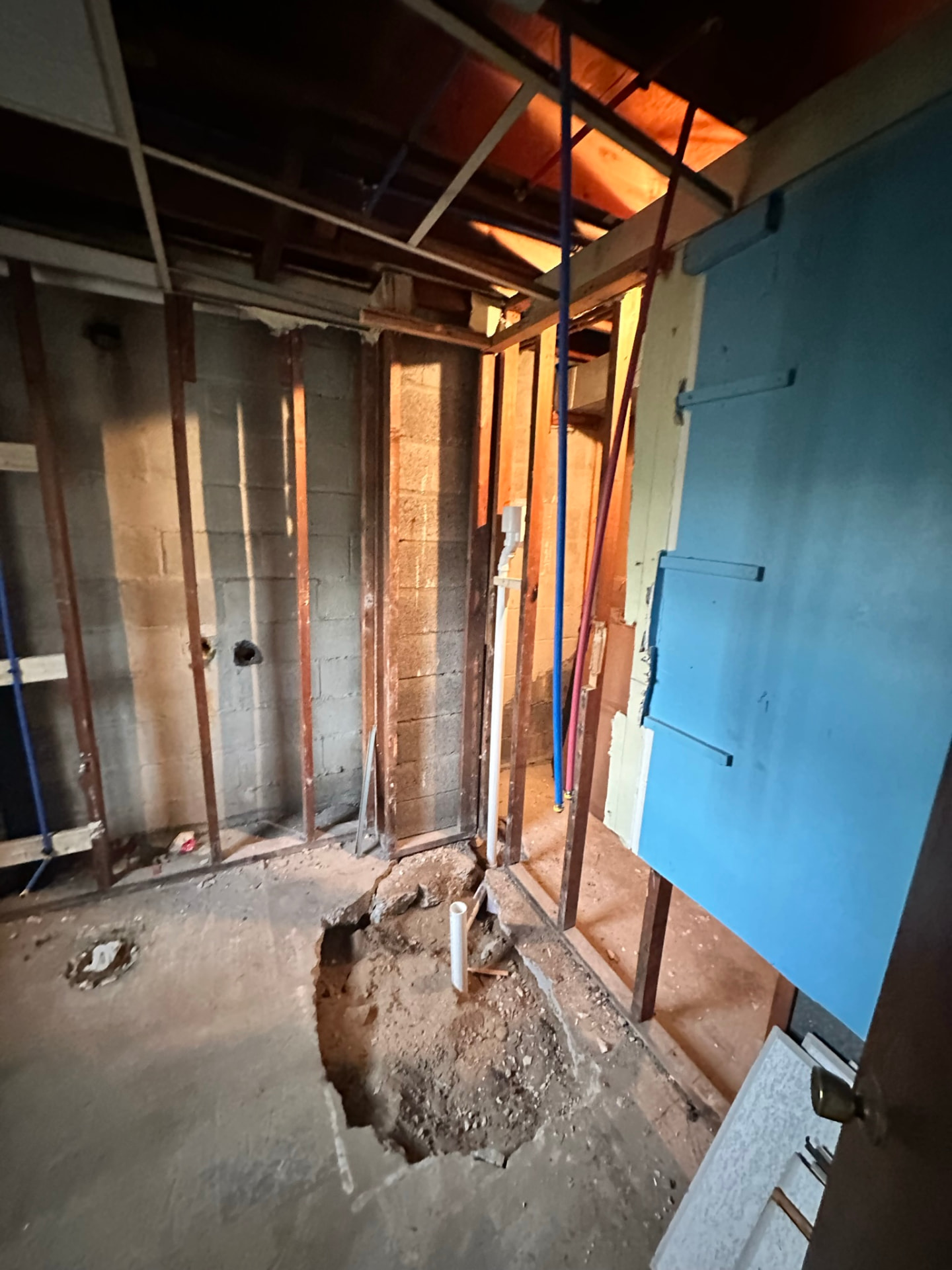 Basement wall and slab opened for new drain and water rough-in piping