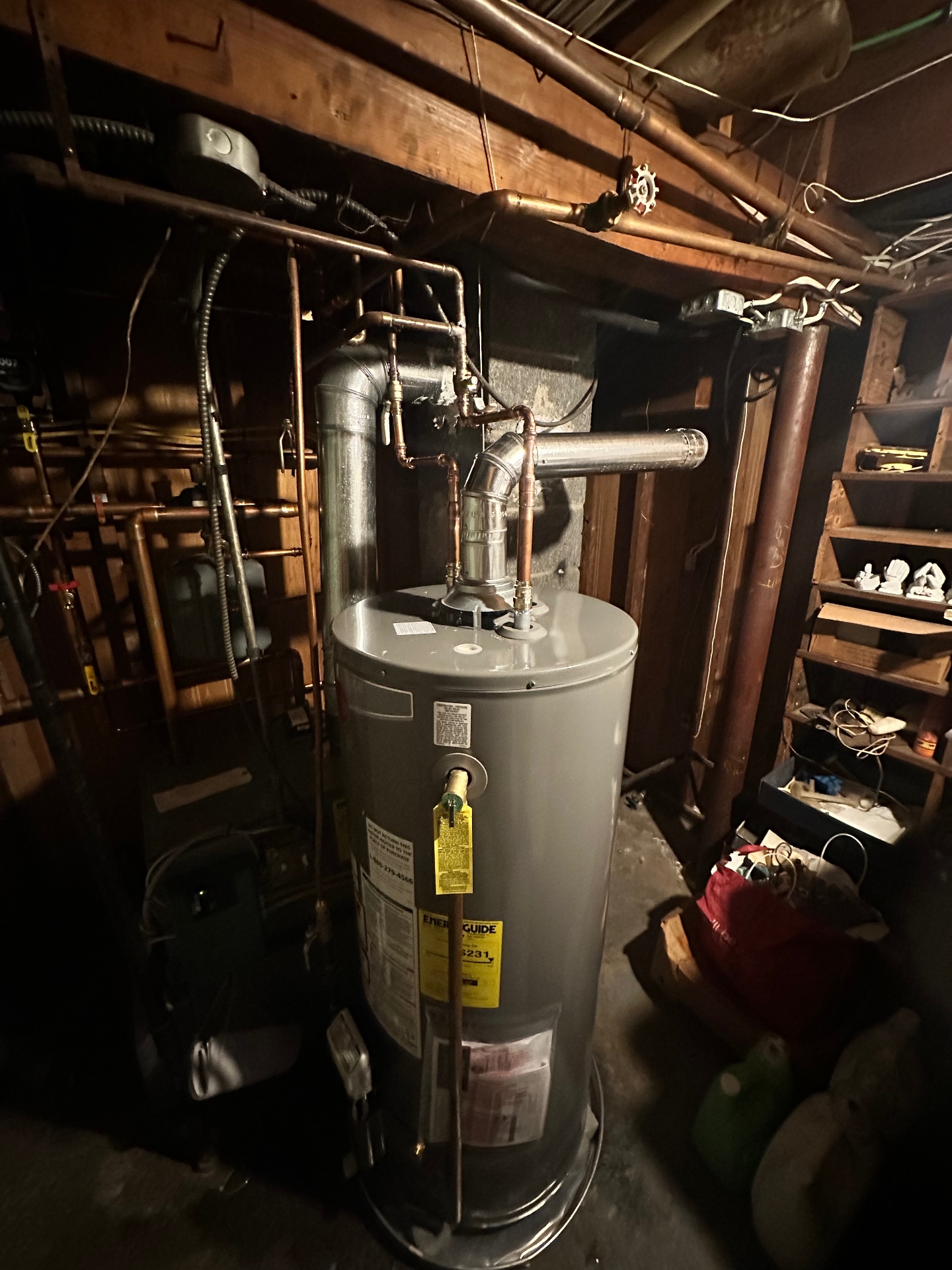 Traditional gas tank water heater swap — new copper flex connectors, sediment trap on the gas line, and a proper draft hood for safe combustion venting.