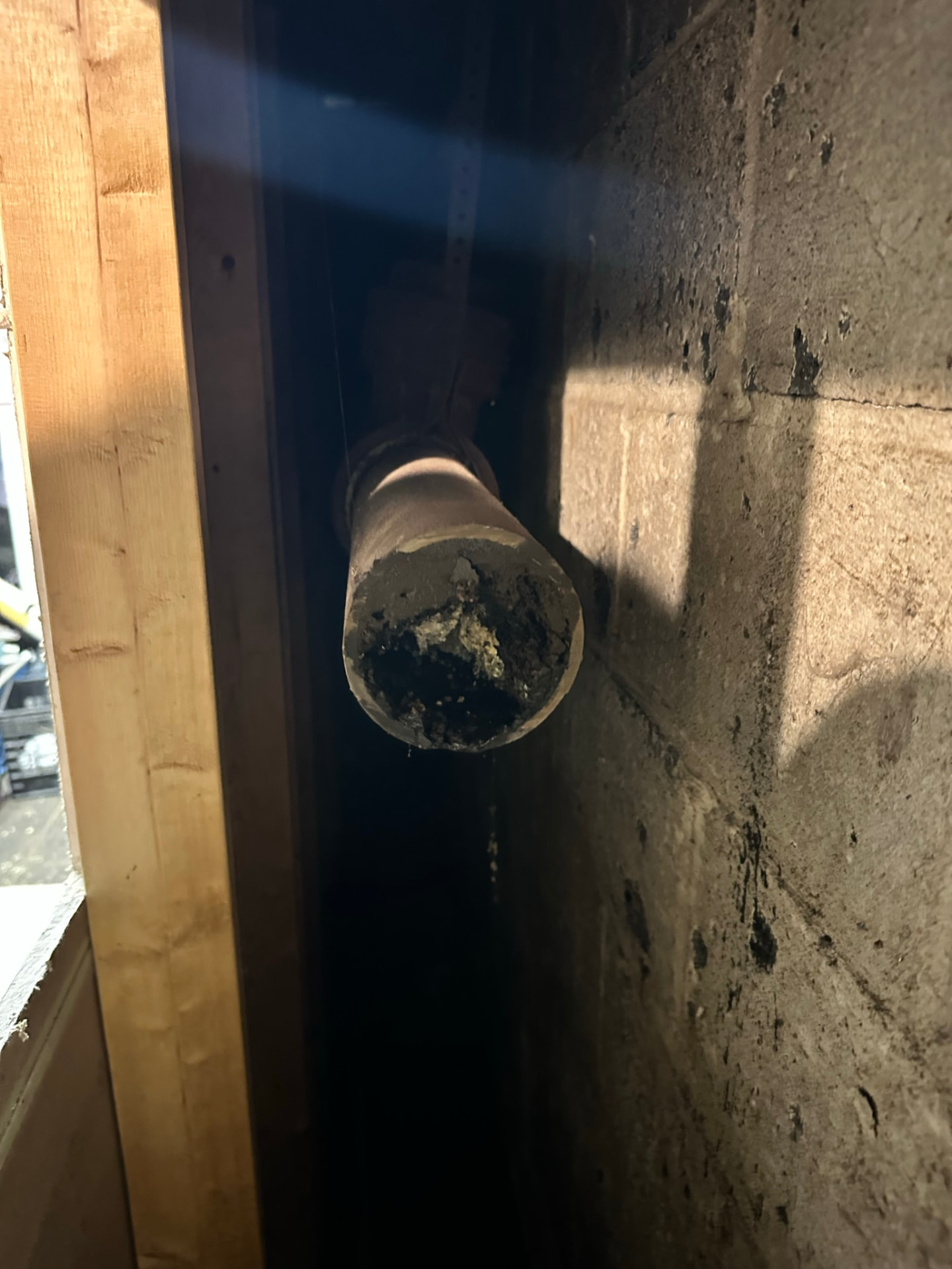 Cut section of old corroded pipe showing heavy interior buildup narrowing the opening
