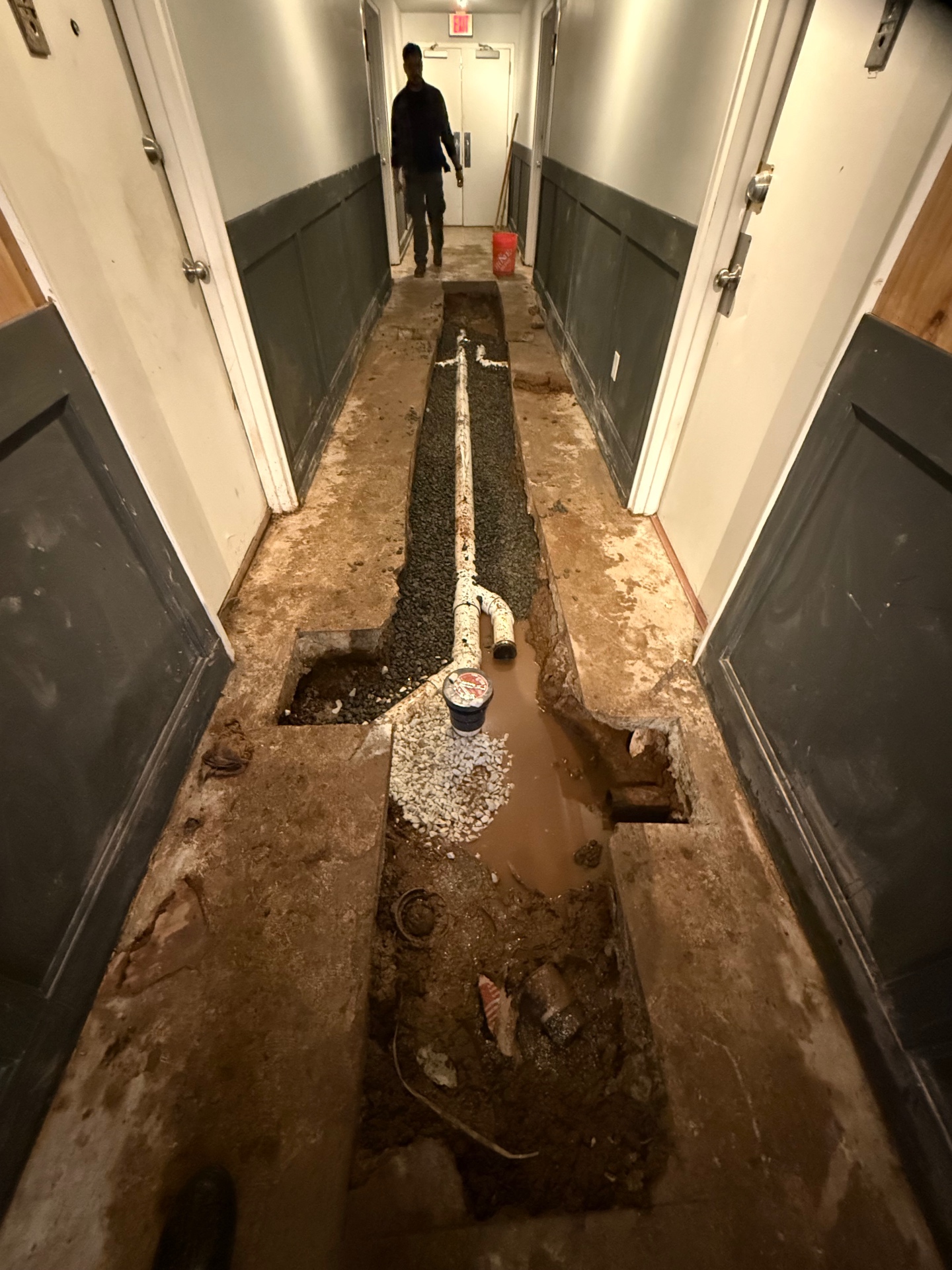 New Schedule 40 PVC drain line installed, bedded in gravel, and ready for inspection before the slab is patched and the hallway is restored.