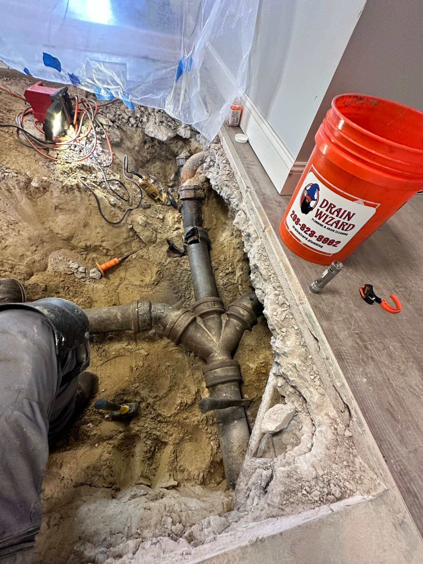 Old cast iron waste line and Y fitting exposed in an opened concrete slab during a Bethany area repair