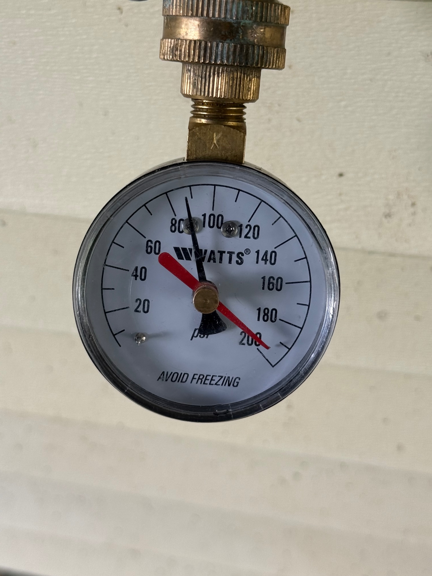 Watts water pressure gauge reading approximately 90 PSI during a Cheshire service call