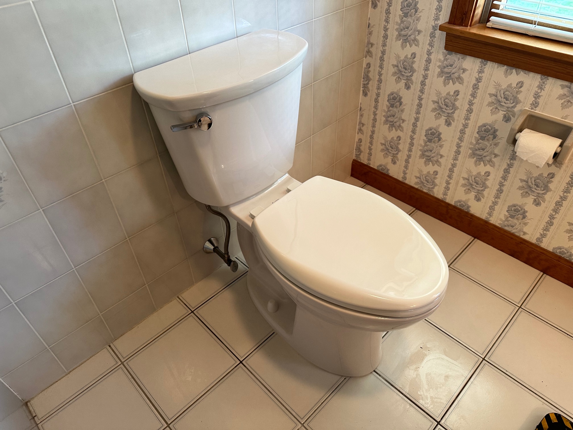 Newly installed white toilet in a tiled Wallingford bathroom